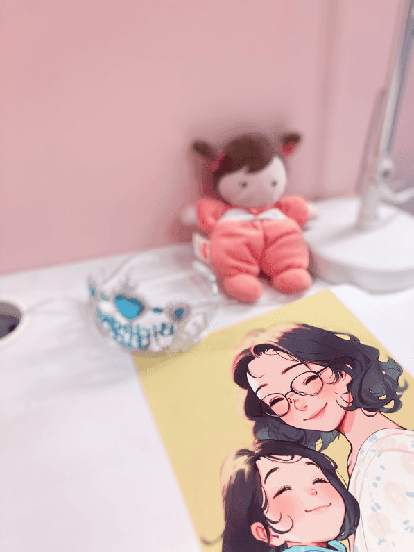 A doll, birthday crown and illustration of Saya with her mother